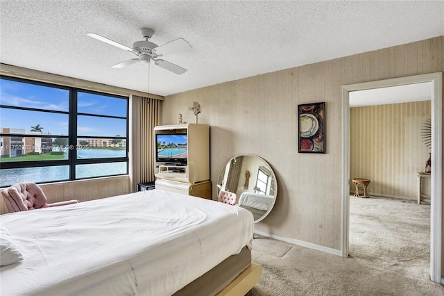 bedroom featuring a ceiling fan, light colored carpet, a textured ceiling, and baseboards