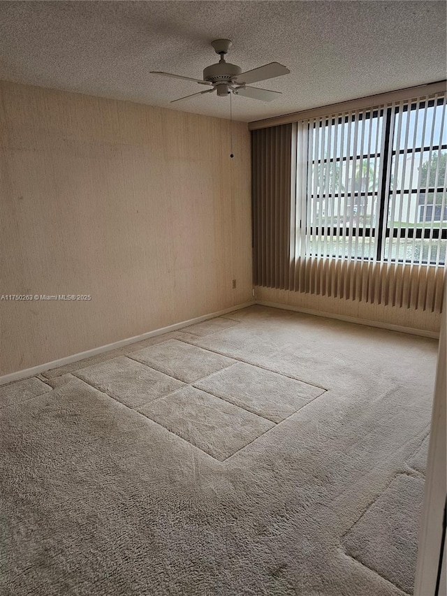 carpeted spare room with ceiling fan, a textured ceiling, and baseboards