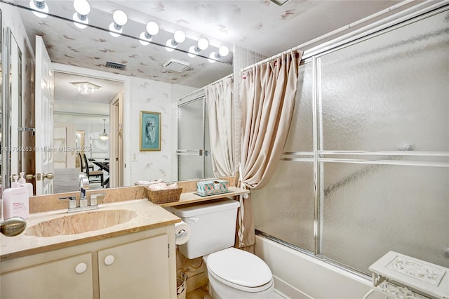 bathroom featuring visible vents, combined bath / shower with glass door, vanity, and toilet