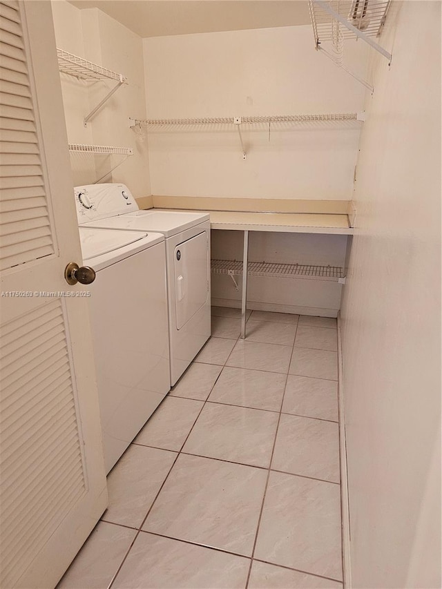 laundry room featuring laundry area, separate washer and dryer, and light tile patterned flooring