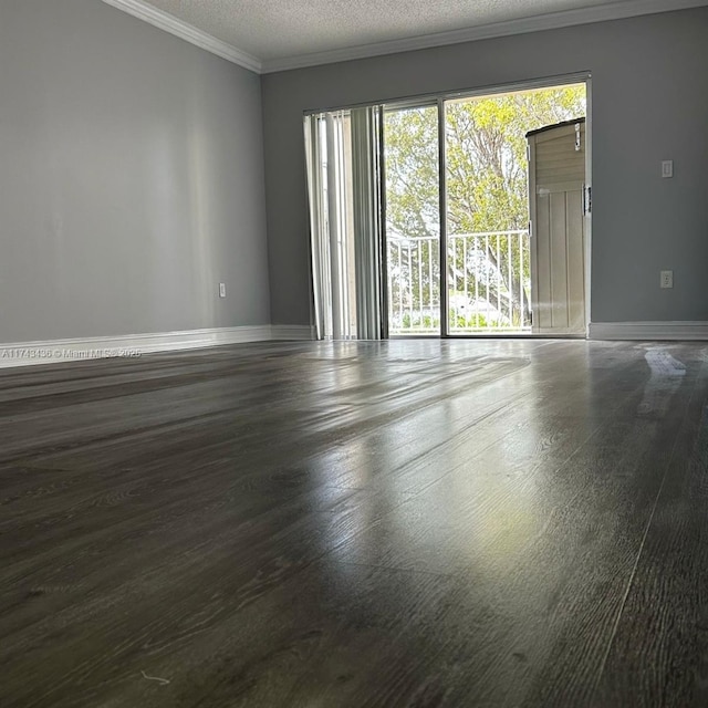 unfurnished room with crown molding, baseboards, a textured ceiling, and wood finished floors