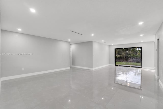 empty room featuring baseboards and recessed lighting