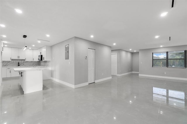 kitchen with open floor plan, light countertops, white cabinetry, and pendant lighting