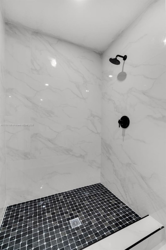 bathroom featuring a marble finish shower