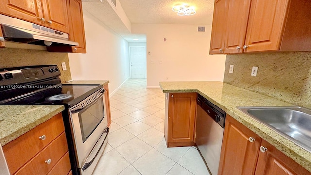 kitchen with light tile patterned floors, appliances with stainless steel finishes, backsplash, and under cabinet range hood