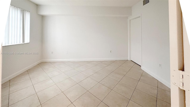 unfurnished room with visible vents, baseboards, and light tile patterned floors