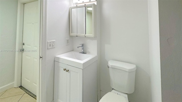 half bath featuring toilet, tile patterned flooring, and vanity