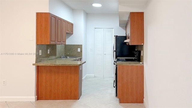 kitchen featuring range with electric cooktop, a sink, backsplash, and light tile patterned floors