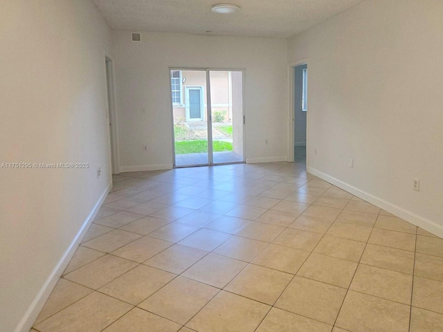 unfurnished room with visible vents, baseboards, and light tile patterned flooring