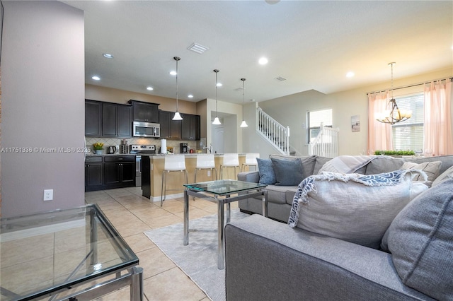 living room with stairs, light tile patterned flooring, visible vents, and recessed lighting