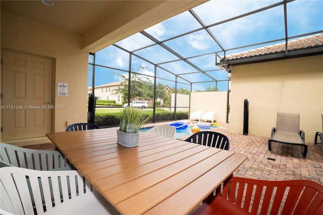 view of patio / terrace featuring outdoor dining space, a lanai, and a pool