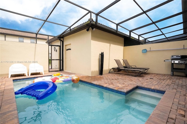 pool featuring glass enclosure, a hot tub, a grill, and a patio