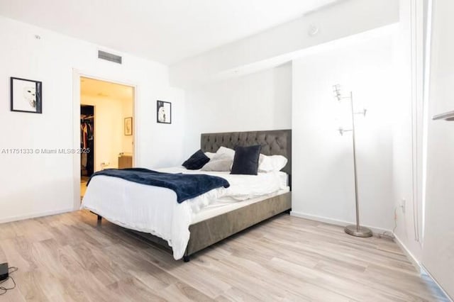 bedroom featuring visible vents, light wood-style flooring, and baseboards