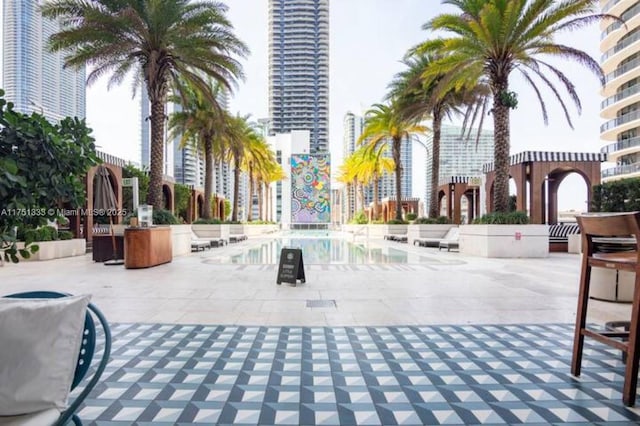 view of property's community featuring a view of city, a patio, and a swimming pool