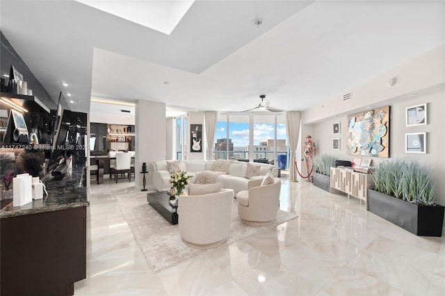 living room featuring marble finish floor, visible vents, a skylight, and floor to ceiling windows