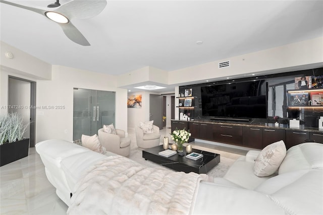 living room featuring ceiling fan and visible vents