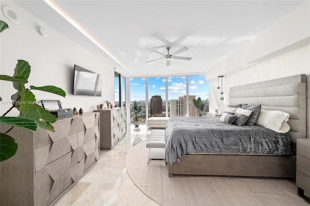 bedroom with a wall of windows, marble finish floor, and a ceiling fan