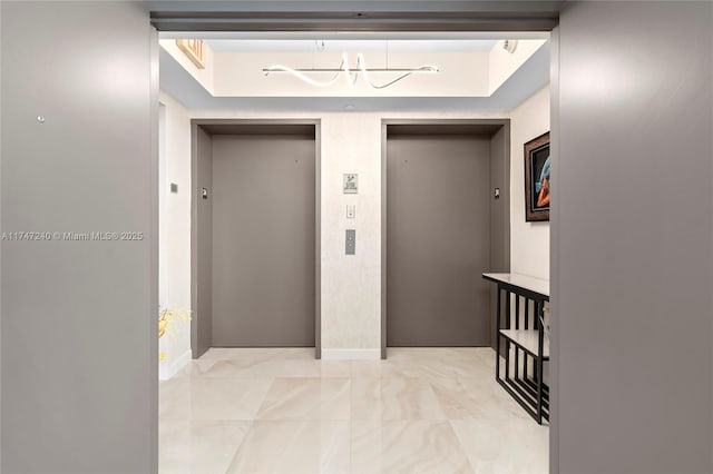 corridor with elevator and baseboards