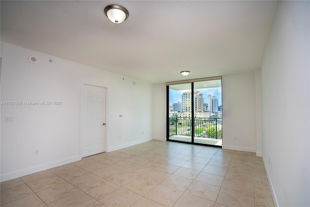 1300 Ponce De Leon Blvd Unit 709, Coral Gables, FL 33134 - unfurnished room featuring floor to ceiling windows, light tile patterned floors, a city view, and baseboards