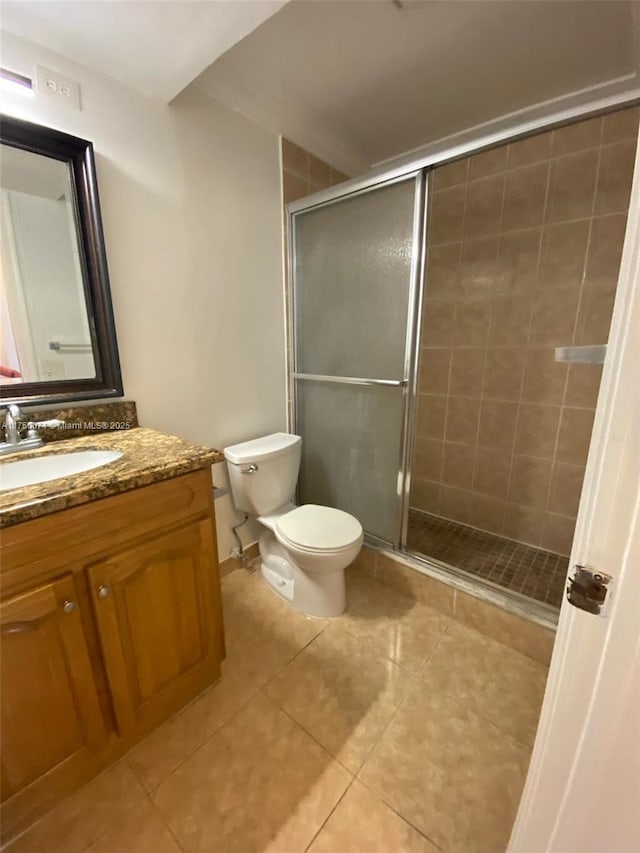 full bathroom with a stall shower, vanity, toilet, and tile patterned floors