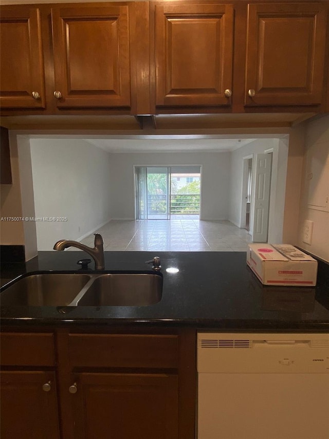 kitchen featuring brown cabinets, a sink, and dishwashing machine