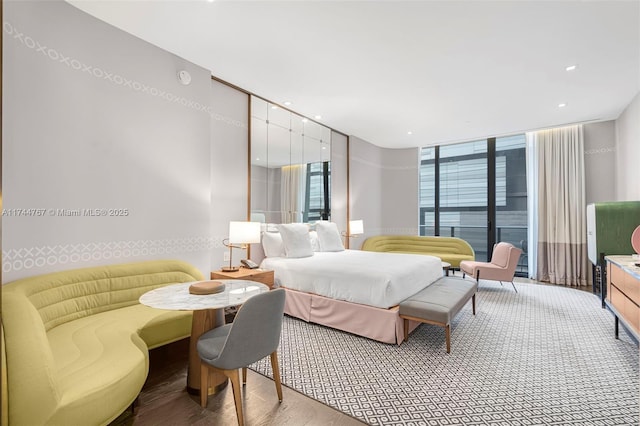 bedroom featuring expansive windows, wood finished floors, and recessed lighting