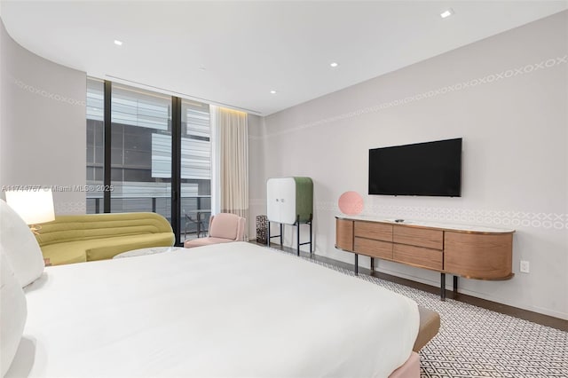 bedroom featuring recessed lighting, expansive windows, and baseboards