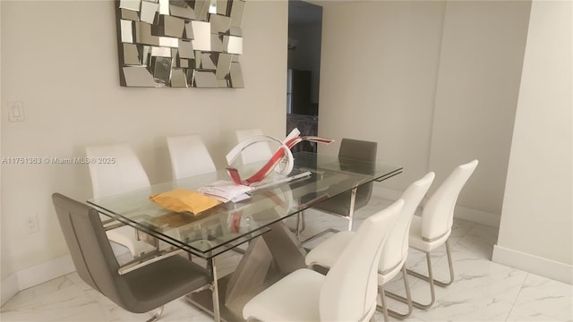 dining space featuring marble finish floor and baseboards