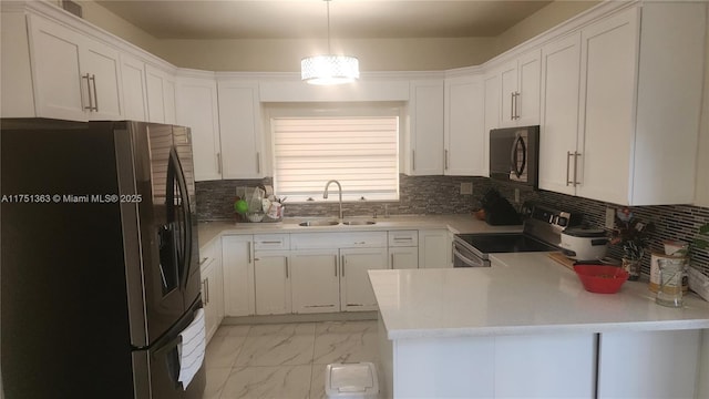 kitchen featuring hanging light fixtures, marble finish floor, stainless steel appliances, light countertops, and a sink