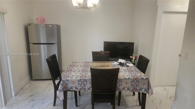 dining room featuring baseboards, marble finish floor, and a notable chandelier