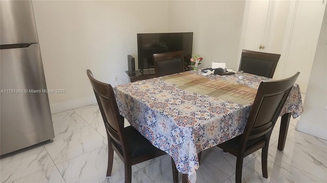 dining space with marble finish floor and baseboards