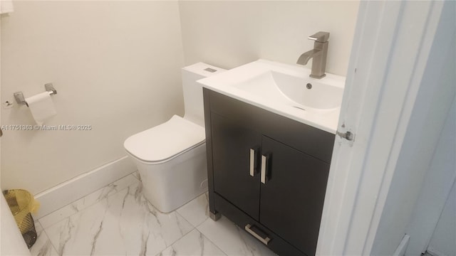 bathroom with marble finish floor, baseboards, vanity, and toilet