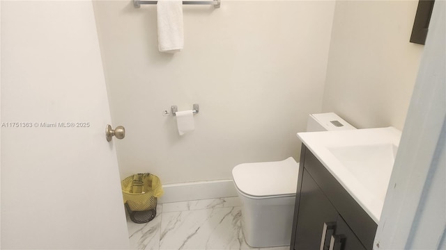 bathroom featuring marble finish floor, baseboards, vanity, and toilet