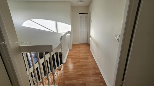 hallway with baseboards and light wood-style floors