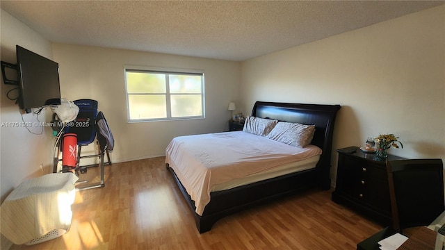 bedroom featuring a textured ceiling and wood finished floors