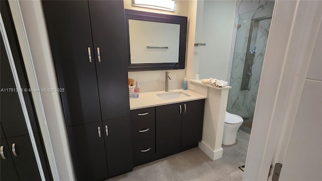 bathroom featuring a marble finish shower, tile patterned flooring, vanity, and toilet