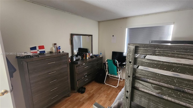 bedroom with light wood finished floors and a textured ceiling