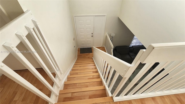 stairs featuring a high ceiling and wood finished floors