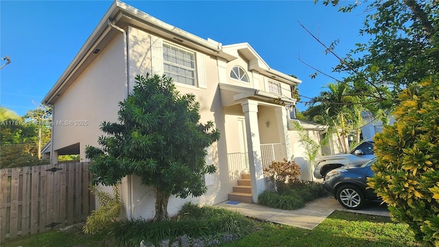 view of front of house featuring fence and stucco siding