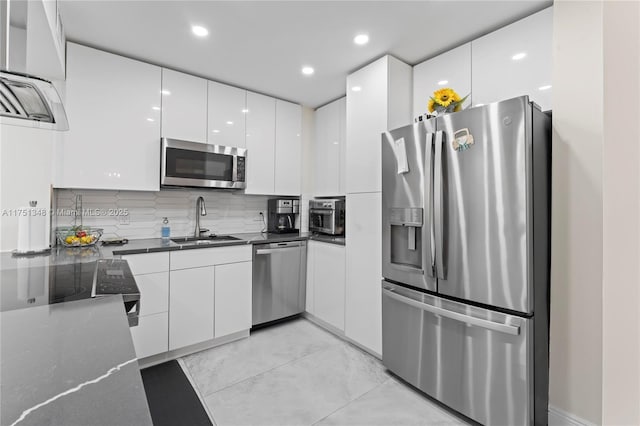 kitchen with stainless steel appliances, white cabinetry, a sink, and modern cabinets