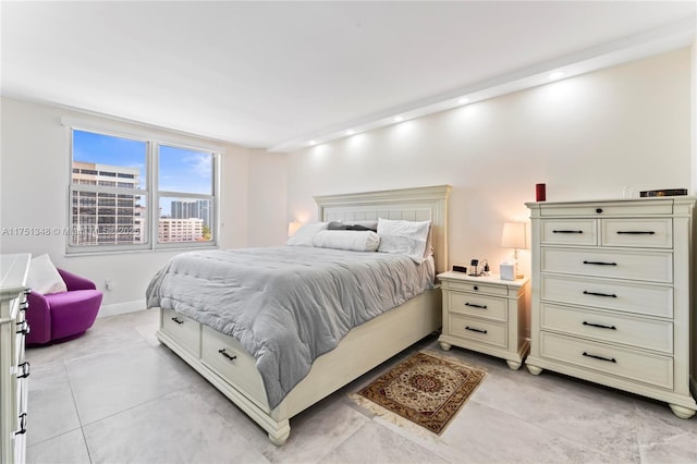 bedroom with light tile patterned floors, recessed lighting, baseboards, and a city view