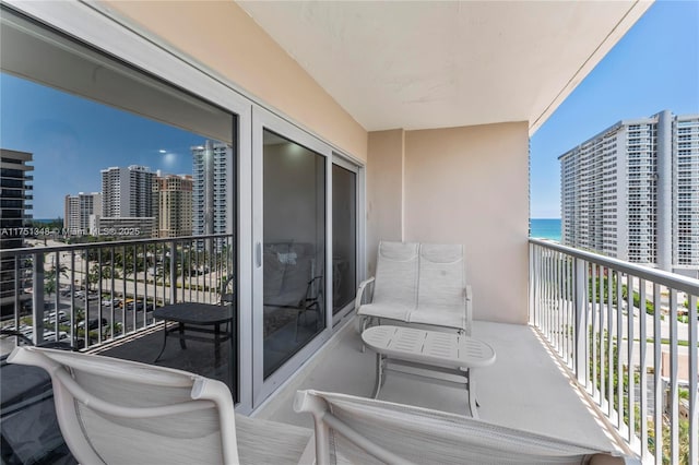 balcony with a water view and a view of city