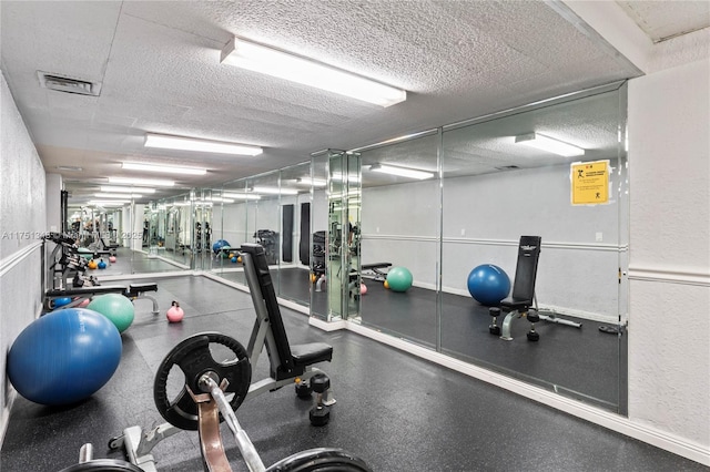 workout area with visible vents and a textured ceiling