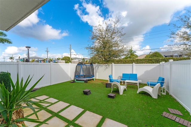 view of yard featuring a patio, a trampoline, outdoor lounge area, and a fenced backyard