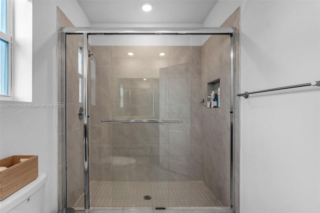 full bathroom featuring toilet and a stall shower