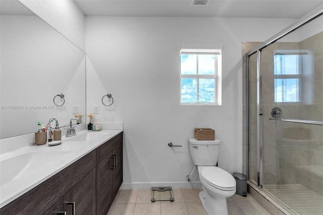 bathroom with tile patterned flooring, a sink, a shower stall, and toilet