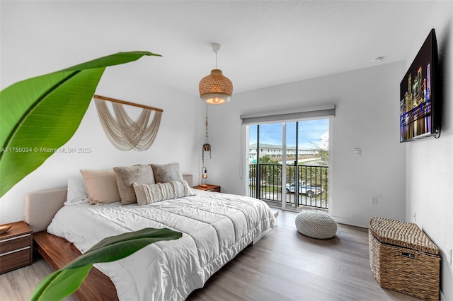 bedroom with access to exterior and wood finished floors