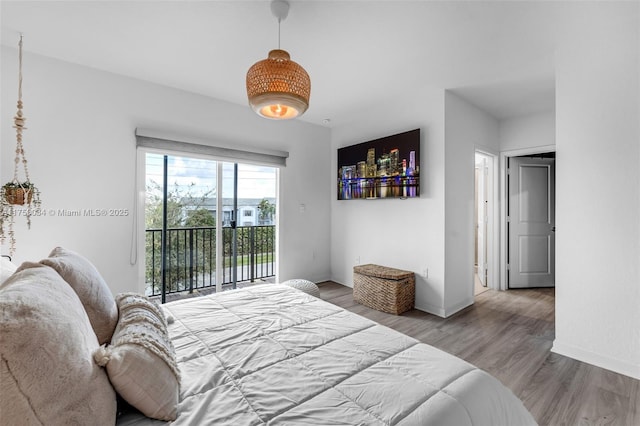 bedroom with access to outside, baseboards, and wood finished floors