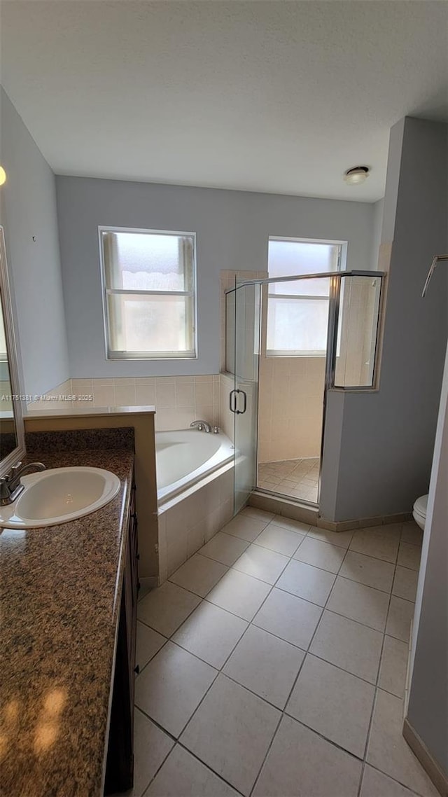 bathroom featuring a garden tub, toilet, vanity, a shower stall, and tile patterned flooring