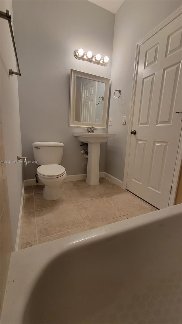 bathroom with tile patterned flooring, a sink, toilet, and baseboards